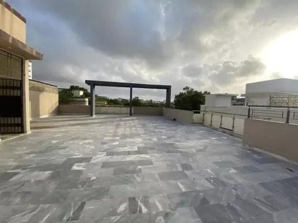 Spacious Rooftop Terrace Of Luxury Townhouse For Sale In Pechs Karachi With Gray Tiled Flooring, Central Pergola, Railings An