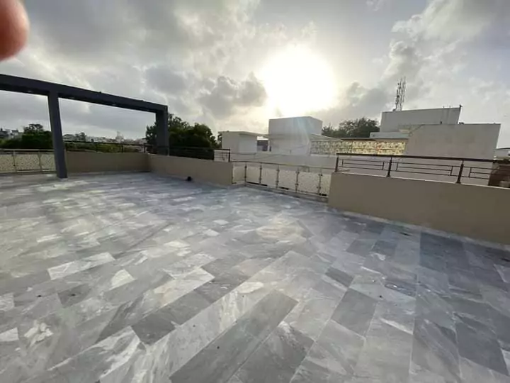 Luxury Townhouse for Sale in PECHS Block 2 Main Khalid Bin Waleed Road Karachi at Prime Location (6) Spacious open terrace with marble flooring, metal railings, pergola, and city views in PECHS townhouse for sale Karachi