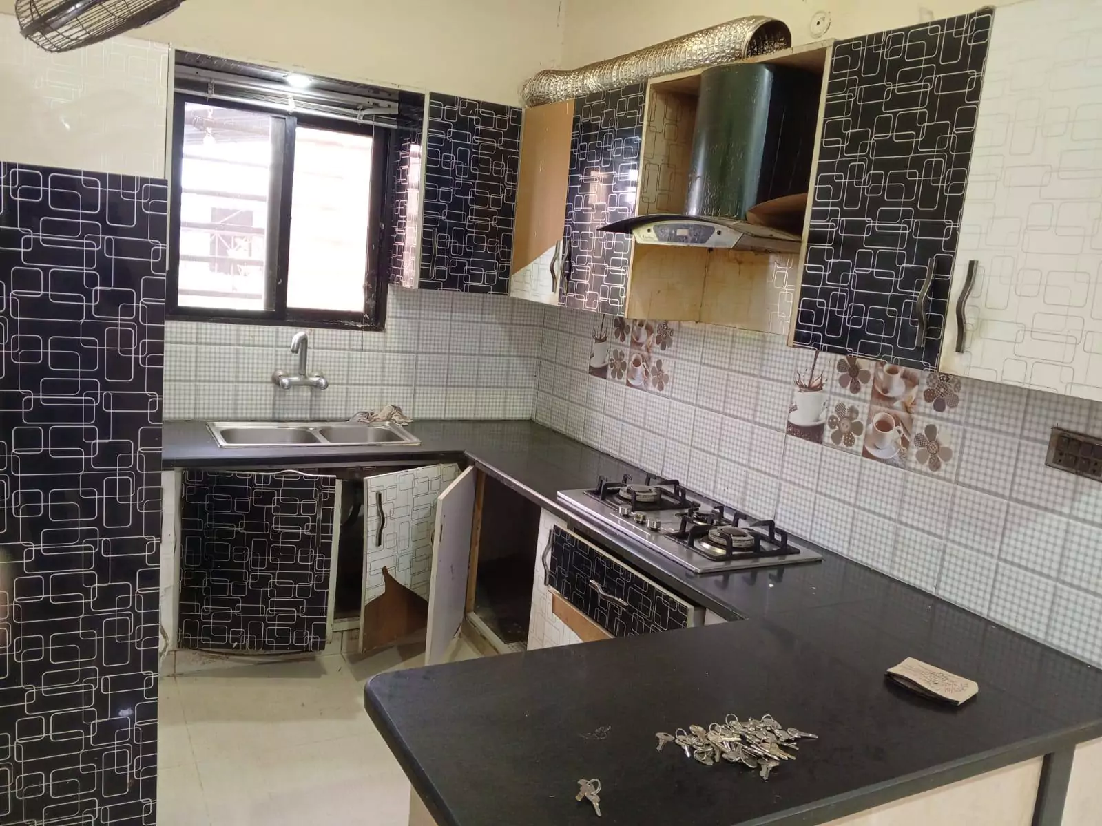 Luxury 3-Bedroom Portion for Rent in PECHS Block 6, Karachi (2) Modern kitchen in luxury 3-bedroom portion for rent in PECHS Block 6 Karachi with black geometric cabinets, double sink, gas