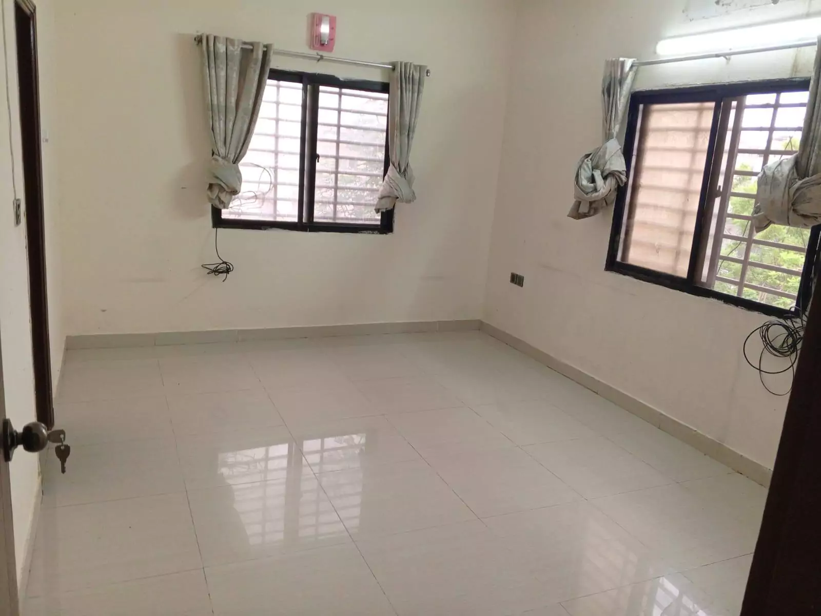 Luxury 3-Bedroom Portion for Rent in PECHS Block 6, Karachi (3) Spacious empty bedroom with shiny white tile flooring, large curtained windows, and open door in luxury 3-bedroom portion for
