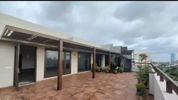 Spacious Terrace Of Luxury Penthouse For Rent In Dha Phase 5 With Wooden Pergola, Terracotta Tiles, Glass Doors, Potted Plant