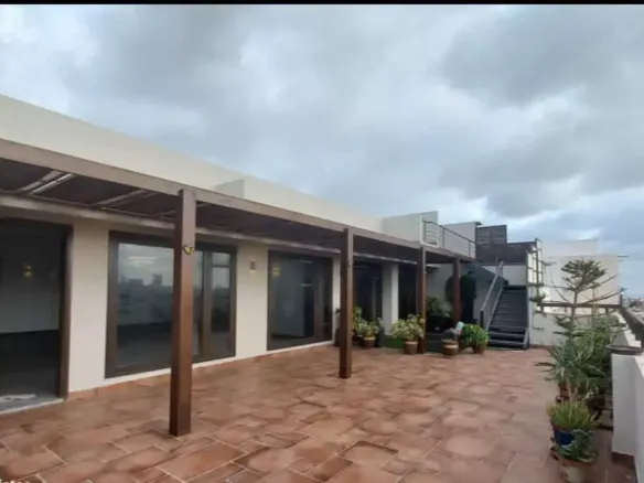 Spacious Terrace Of Luxury Penthouse For Rent In Dha Phase 5 With Wooden Pergola, Terracotta Tiles, Glass Doors, Potted Plant