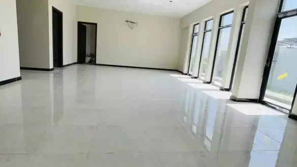 Spacious Open-Plan Room With Polished White Marble Floors, Large Floor-To-Ceiling Windows, Beige Walls, High Ceilings, And Mu