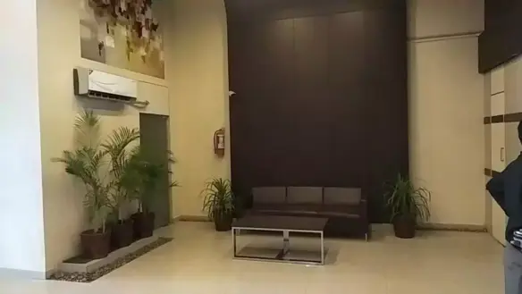 Spacious lounge in luxury 1635 sqft rented office for sale in Clifton Diamond with brown leather sofa, glass table, potted pa