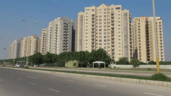 Creek Vista Apartments High-Rise Towers In Dha Phase 8 Karachi, Modern Beige Buildings With Balconies Along Tree-Lined Road