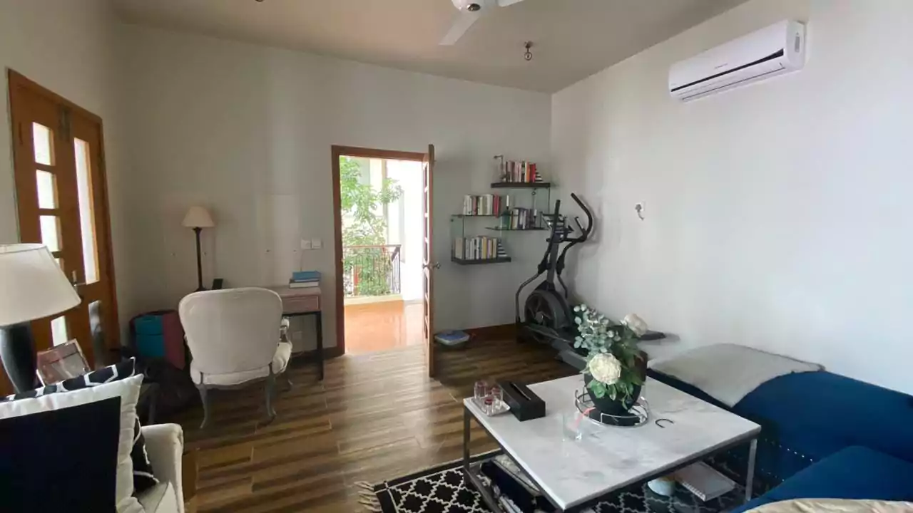 Elegant 500 Square Yards Bungalow for Sale in DHA Phase 6, Karachi (15) Spacious living room in 500 sq yd bungalow DHA Phase 6 with sofa, exercise bike, bookshelves, desk, balcony door