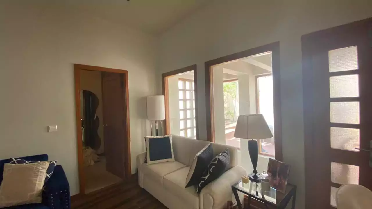 Elegant 500 Square Yards Bungalow for Sale in DHA Phase 6, Karachi (4) Elegant living room in 500 sq yd bungalow DHA Phase 6 with white sofa, black cushions, floor lamps, wooden floors, frosted gl