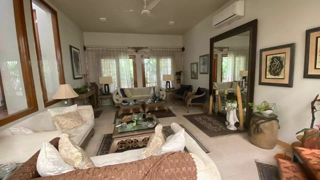 Elegant 500 Square Yards Bungalow for Sale in DHA Phase 6, Karachi (5) Spacious living room in elegant 500 sq yd bungalow DHA Phase 6 with white sofas, glass coffee table, large wooden windows, ce