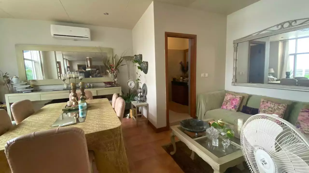 Elegant 500 Square Yards Bungalow for Sale in DHA Phase 6, Karachi (8) Elegant dining and living room in 500 sq yd bungalow DHA Phase 6 with wooden table, upholstered chairs, sofas, large mirrors,