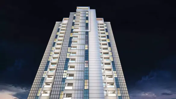Night View Of Greens Three Clifton High-Rise Apartment Facade With Glass Panels, White Cladding, And Multiple Balconies