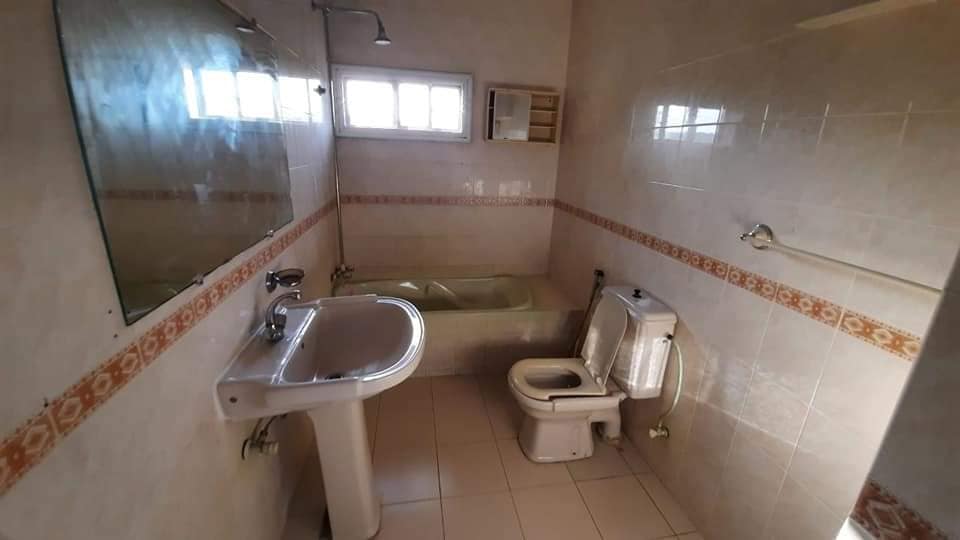 Fully Furnished Portion for Rent in DHA Phase 4, Karachi (3) Bathroom with pedestal sink, white toilet, bathtub, showerhead, mirror, tiled walls and floor in DHA Phase 4 portion