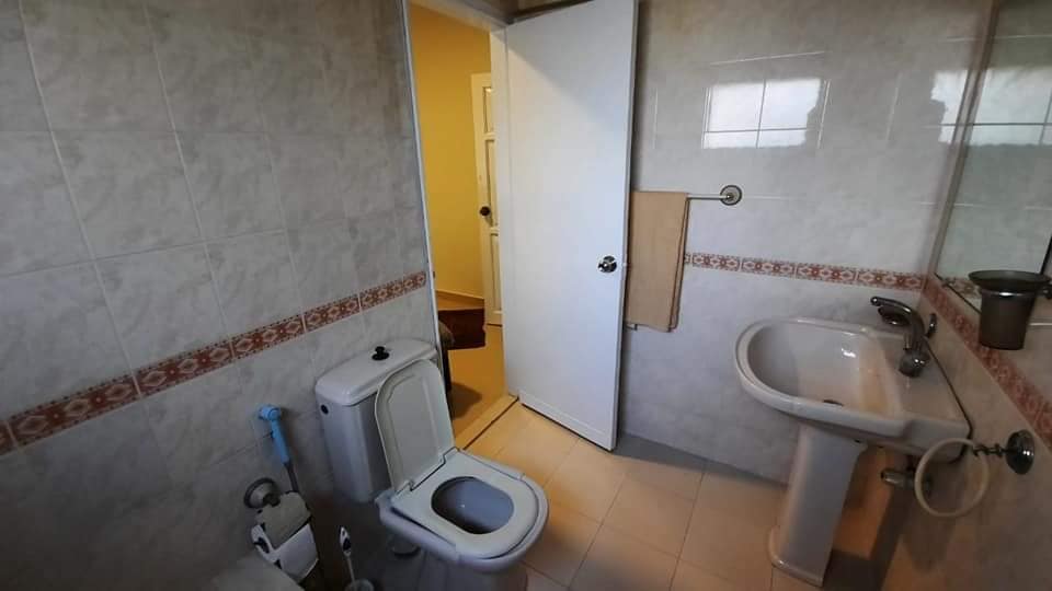 Fully Furnished Portion for Rent in DHA Phase 4, Karachi (5) Bathroom featuring white toilet, pedestal sink, tiled walls with red border, towel rack in fully furnished portion for rent i