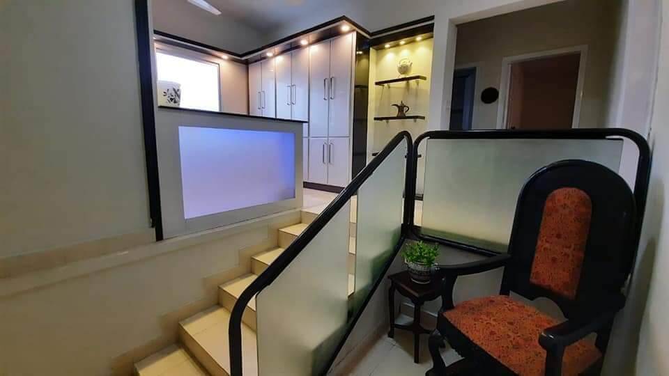 Fully Furnished Portion for Rent in DHA Phase 4, Karachi (6) Modern kitchen cabinets, glass-railed staircase, and seating area in fully furnished portion for rent in DHA Phase 4, Karachi
