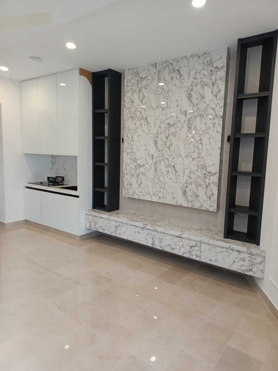 Brand New Stylish Bungalow For Rent in DHA Phase 4 Karachi (1) Modern kitchen with white cabinets, marble feature wall, black shelves, sink, and beige tiled floor in stylish bungalow for r