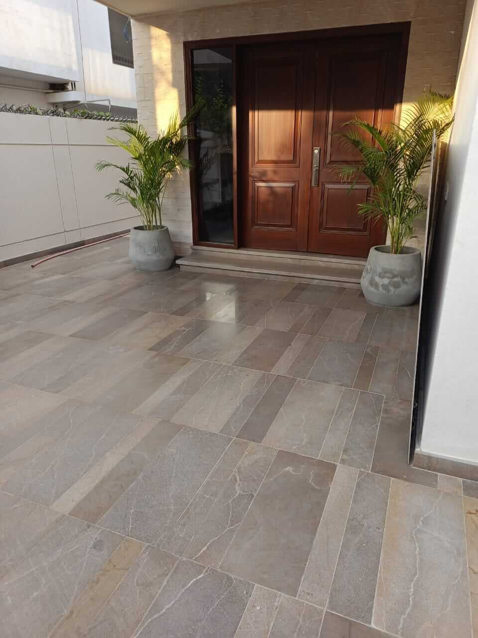Brand New Stylish Bungalow For Rent in DHA Phase 4 Karachi (11) Stylish bungalow entrance with double wooden doors, potted palms and tiled porch in DHA Phase 4 Karachi