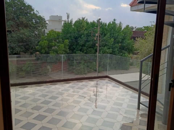 Spacious Modern Balcony With Diamond-Patterned Tiles, Glass Railings, Metal Staircase In Bungalow For Rent In Dha Phase 4 Kar