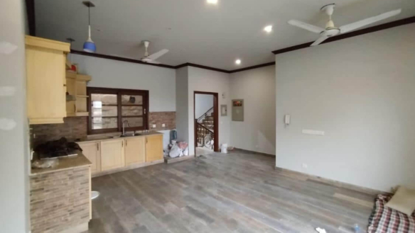 Spacious Kitchen In Luxurious House For Sale In Dha Phase 8, Karachi, With Wooden Floors, Modern Cabinets, Brick Backsplash, 