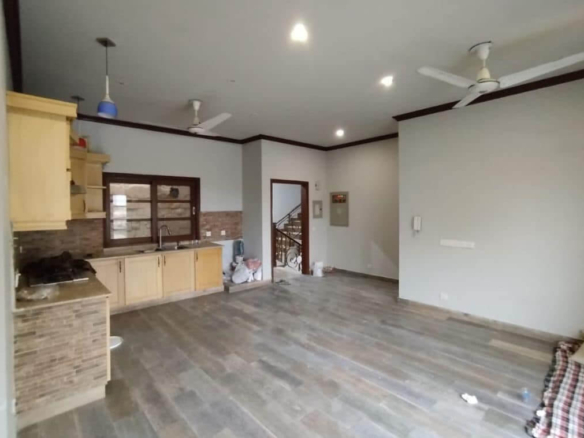 Spacious Kitchen In Luxurious House For Sale In Dha Phase 8, Karachi, With Wooden Floors, Modern Cabinets, Brick Backsplash, 