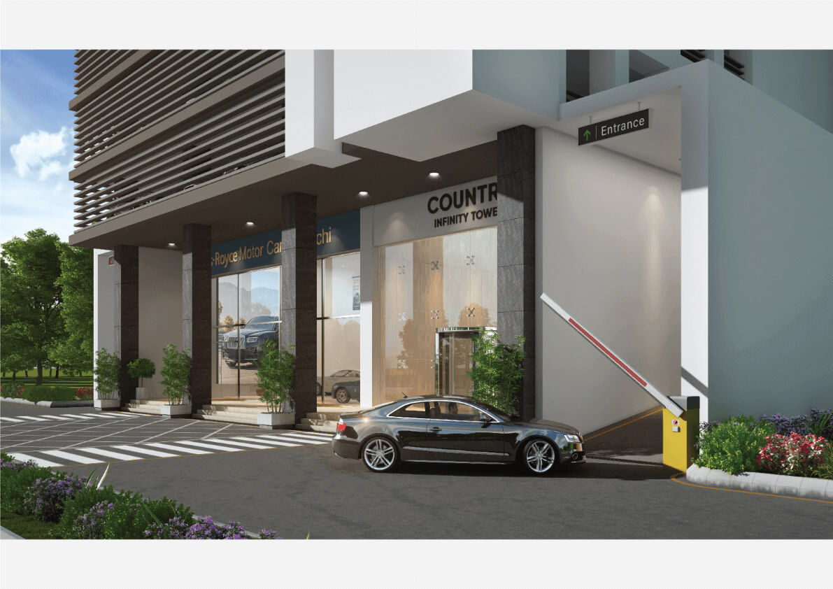 Country Infinity Tower Premium Office Spaces in Clifton, Karachi (3) Entrance to Country Infinity Tower in Clifton with modern glass facade, signage, boom barrier, parked car, and landscaped dri