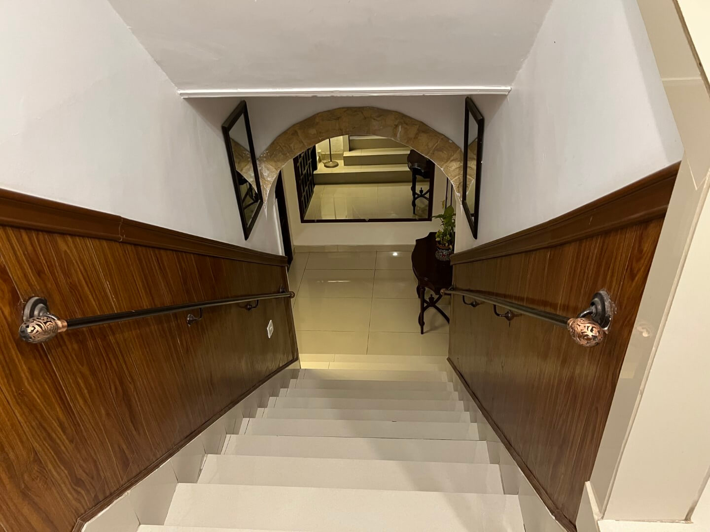 Portion for Rent in DHA Karachi – Fully Furnished Prime Location MaxX Capitals (11) Elegant wooden staircase with ornate handrails and arched doorway framed by mirrors in fully furnished portion for rent in DH