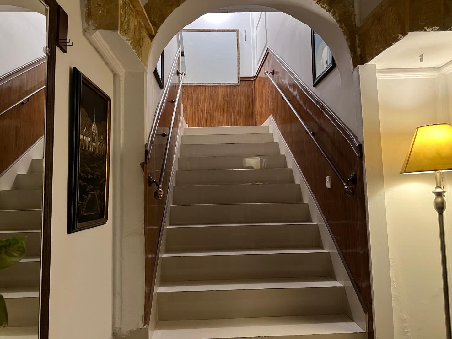 Portion for Rent in DHA Karachi – Fully Furnished Prime Location MaxX Capitals (12) Elegant arched wooden staircase with white marble steps and handrails in fully furnished portion for rent in DHA Karachi