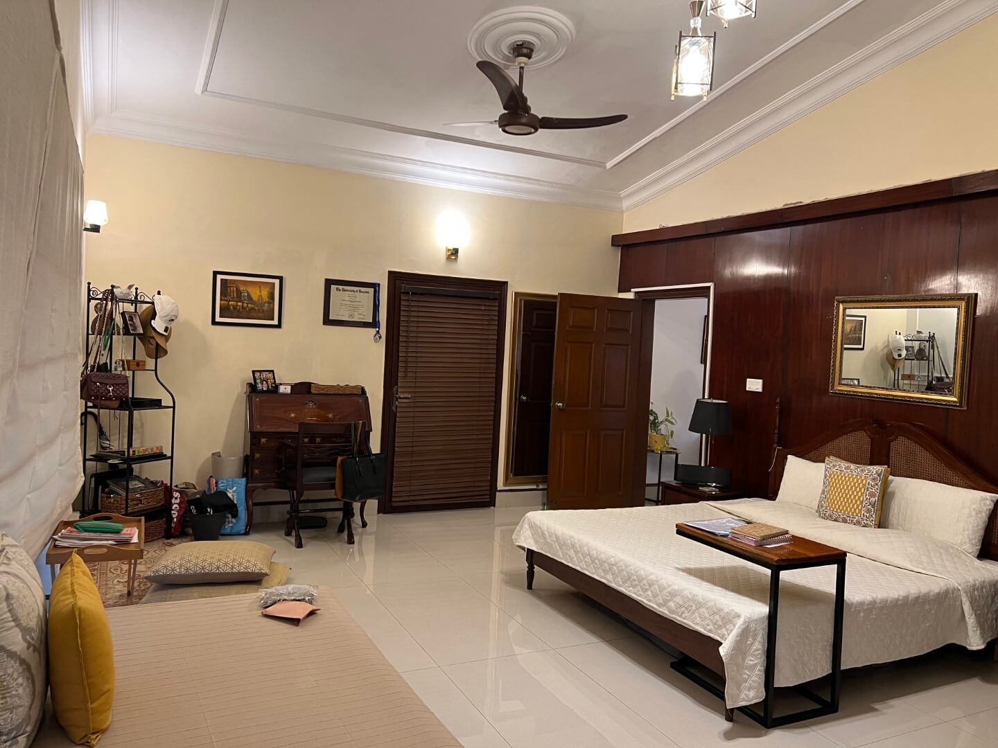 Portion for Rent in DHA Karachi – Fully Furnished Prime Location MaxX Capitals (2) Fully furnished bedroom in Portion for Rent in DHA Karachi with wooden double bed, desk, wardrobe, ceiling fan, and beige wal