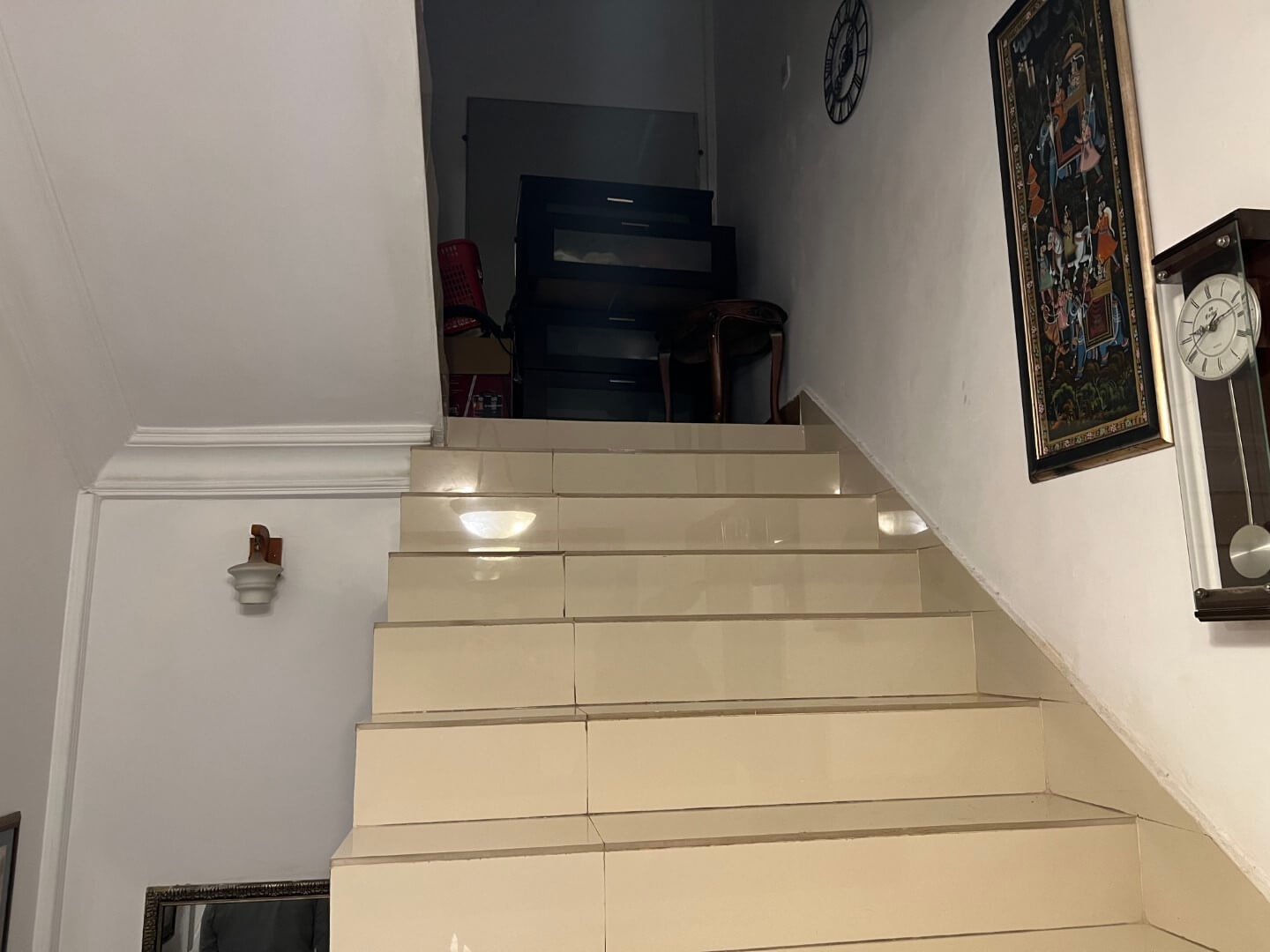 Portion for Rent in DHA Karachi – Fully Furnished Prime Location MaxX Capitals (8) Beige tiled staircase with white walls, wall clock, artwork, red chairs, and black desk in fully furnished portion for rent i