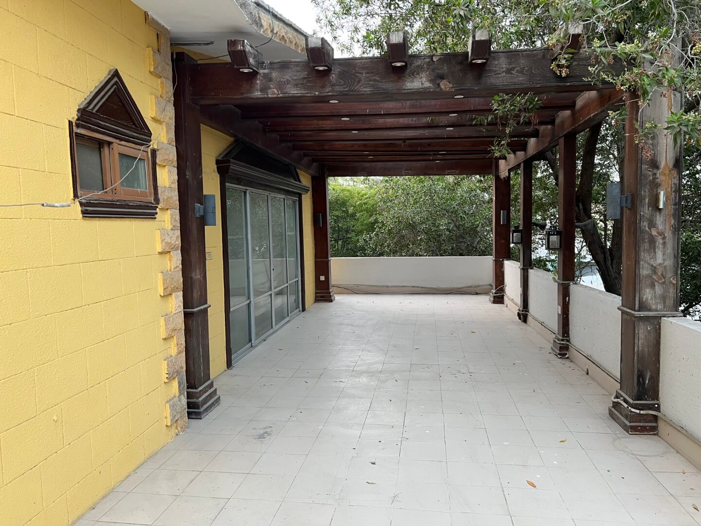 Portion for Rent in DHA Karachi – Fully Furnished Prime Location MaxX Capitals (9) Covered terrace with wooden pergola, sliding glass doors, tiled floor in fully furnished portion for rent in DHA Karachi