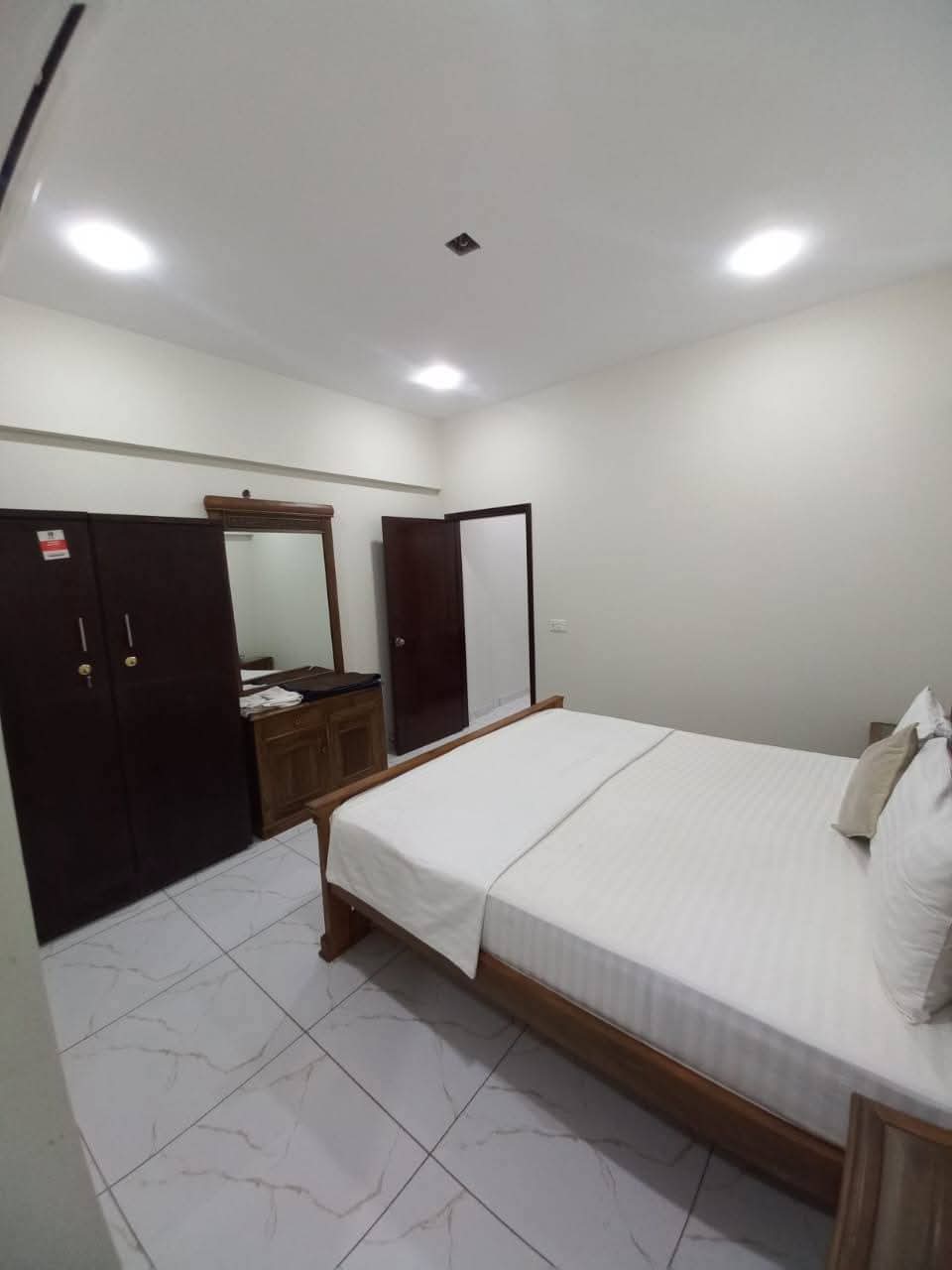 Fully Furnished Studio Apartment For Short & Long Term Rent – DHA Phase 6 MaxX Capitals (2) Bedroom in fully furnished studio apartment, DHA Phase 6 Karachi, with wooden double bed, mirrored wardrobe, tiled floors, re