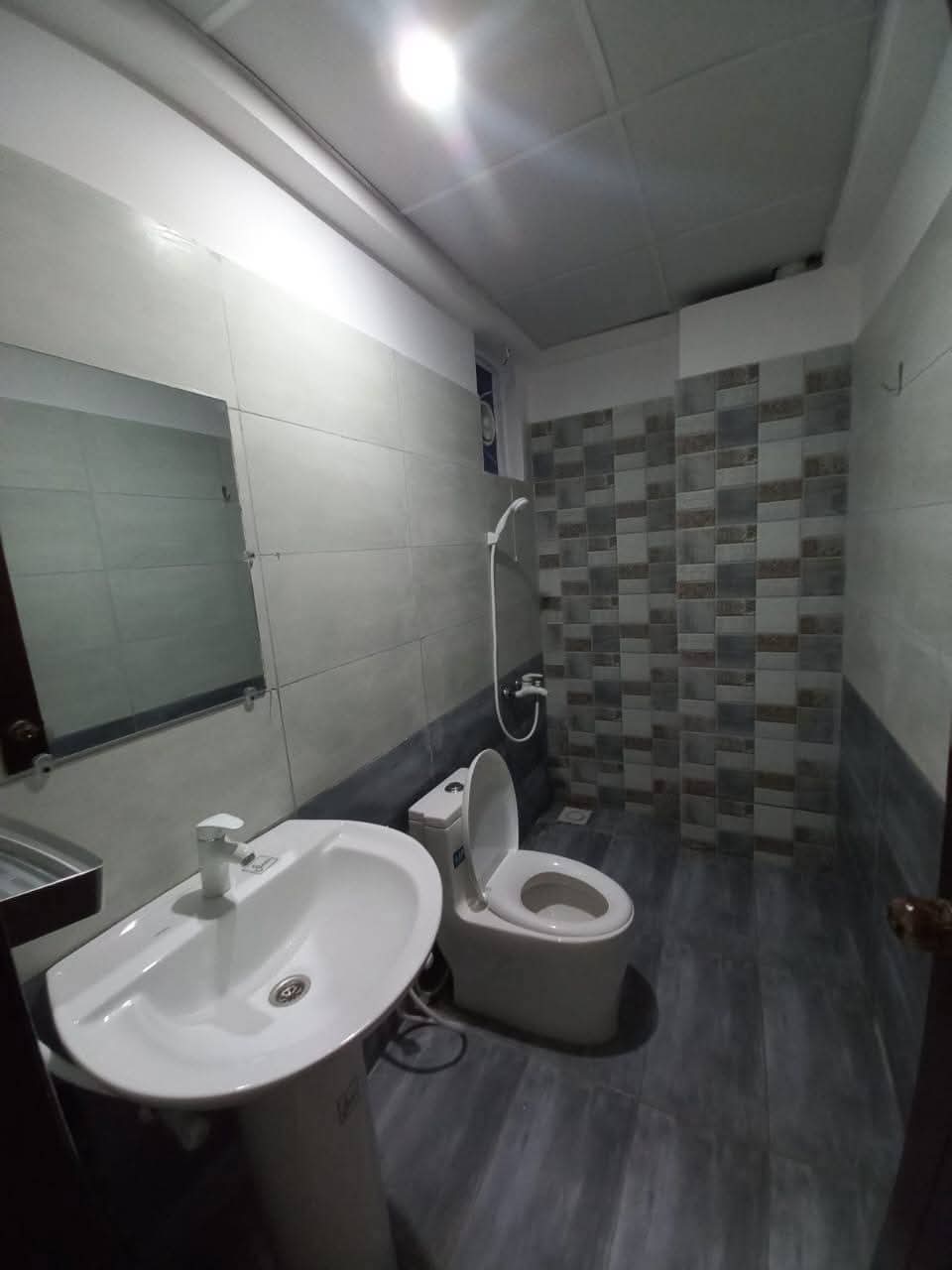 Fully Furnished Studio Apartment For Short & Long Term Rent – DHA Phase 6 MaxX Capitals (5) Bathroom in fully furnished studio apartment DHA Phase 6 Karachi with white sink toilet mosaic tiled shower