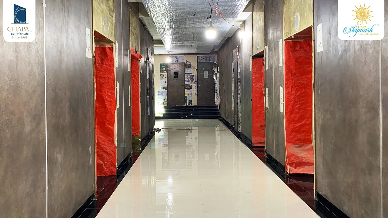 Chapal Skymark – 50-storey Luxury Residential Tower (3) Long corridor in Chapal Skymark 50-storey tower with glossy white floors, gray walls, Chapal Skymark branding, red protective