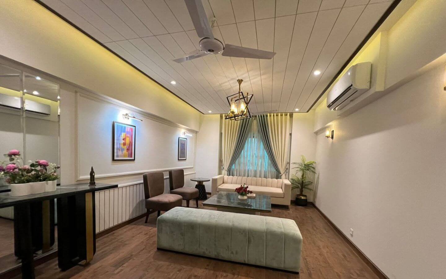 4-Bed Apartment for Sale in Greens 3 Clifton Block 8 MaxX Capitals living room in 4 bed apartment for sale Greens 3 Clifton with sofa, chairs, curtains and ceiling fan