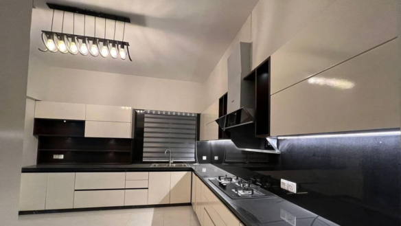 MaxX Capitals modern Clifton Block 8 apartment kitchen with black countertops, built-in cabinets, and gas cooktop